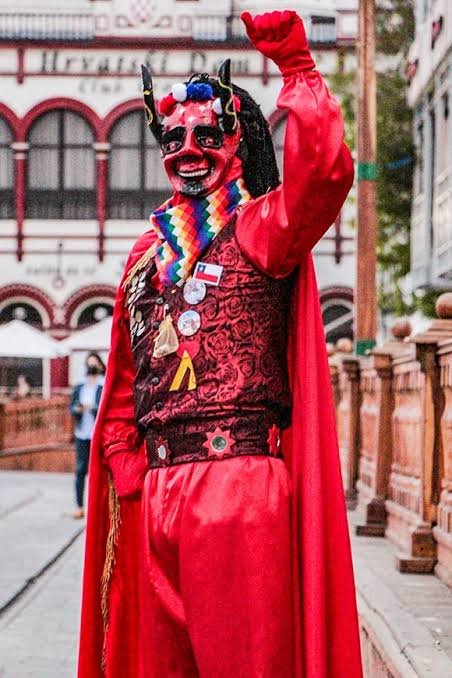 Danzante vestido de Diablo Suelto tiraneño, con capa roja y máscara con cuernos