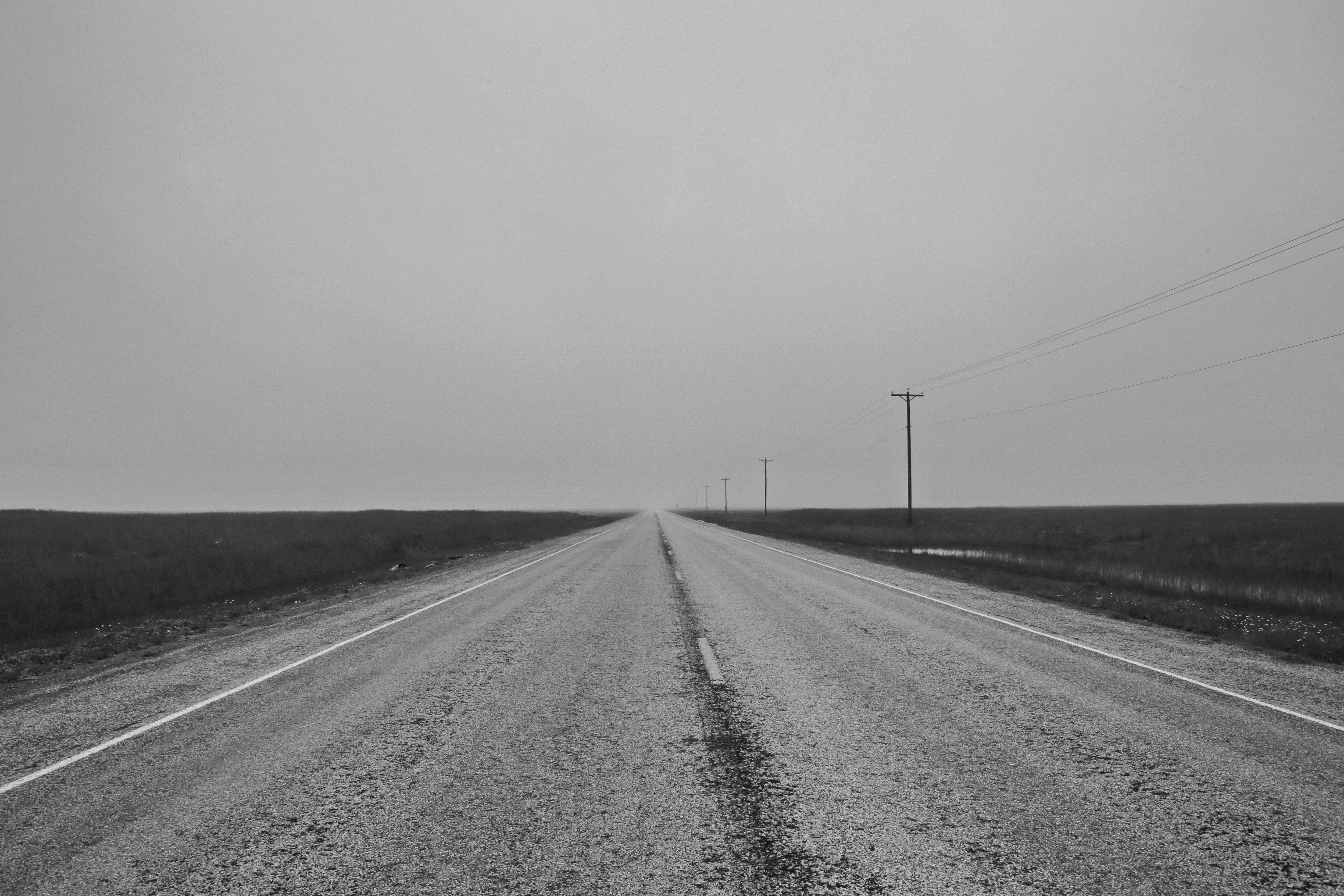 Carretera recta perdiéndose en la niebla hacia el horizonte