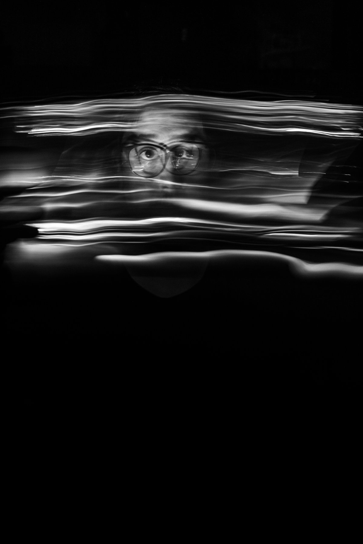 Retrato en blanco y negro con desenfoque de movimiento, mostrando solo los ojos con lentes nítidos